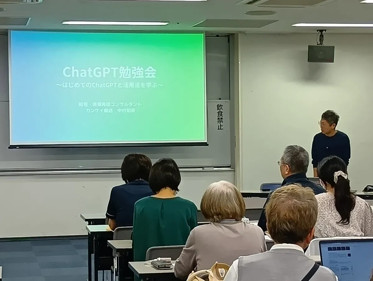 福井市中央公民館でのChatGPT勉強会。スクリーンの横で講師が話している